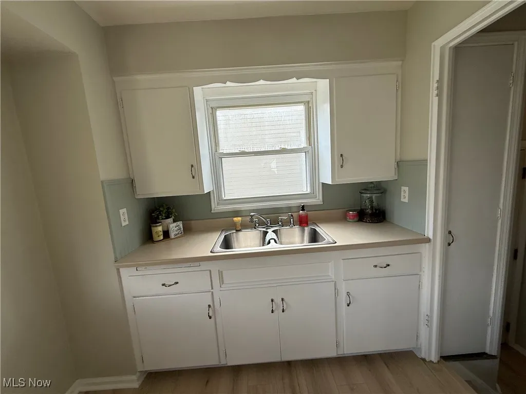 Kitchen with white cabinets, light countertops, and light wood-type flooring