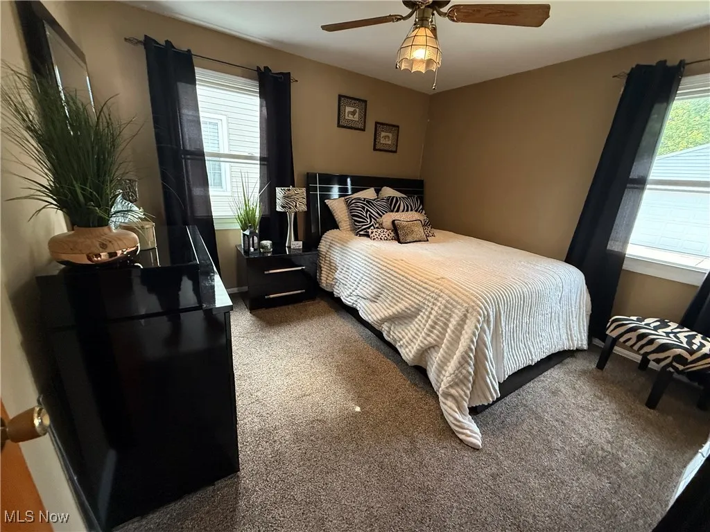 Carpeted bedroom featuring a ceiling fan