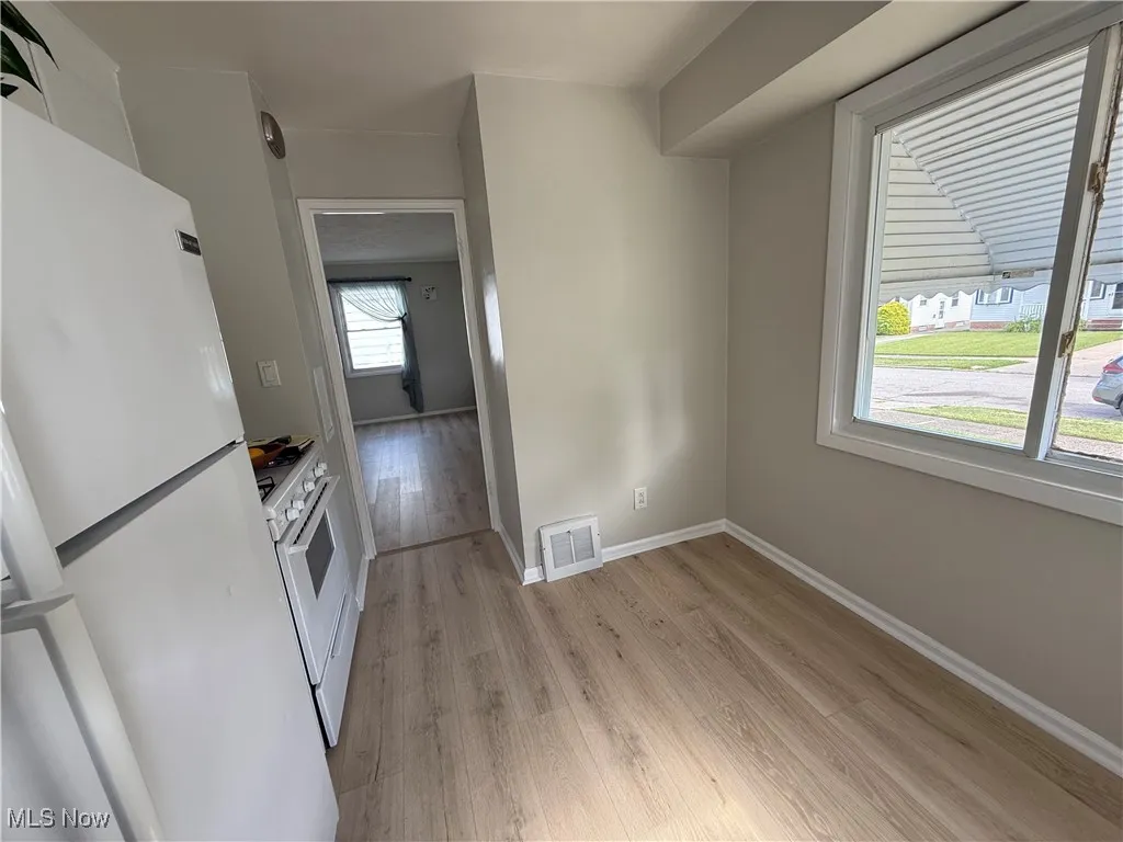 Kitchen featuring white appliances and light wood finished floors