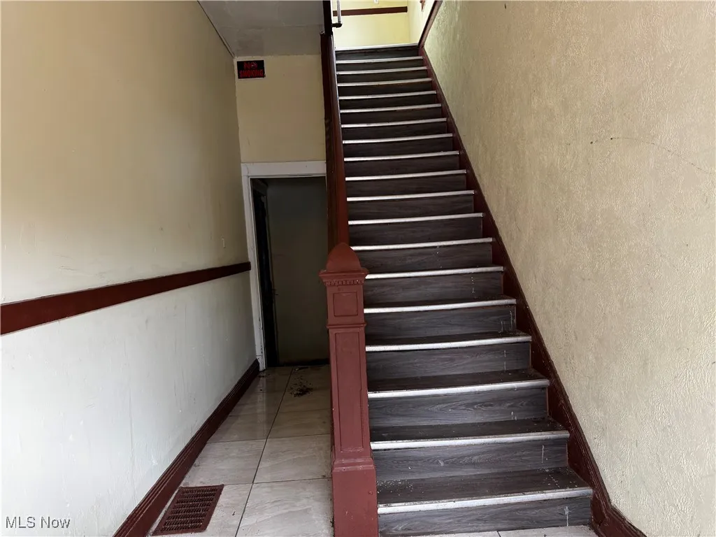 Staircase featuring a textured wall