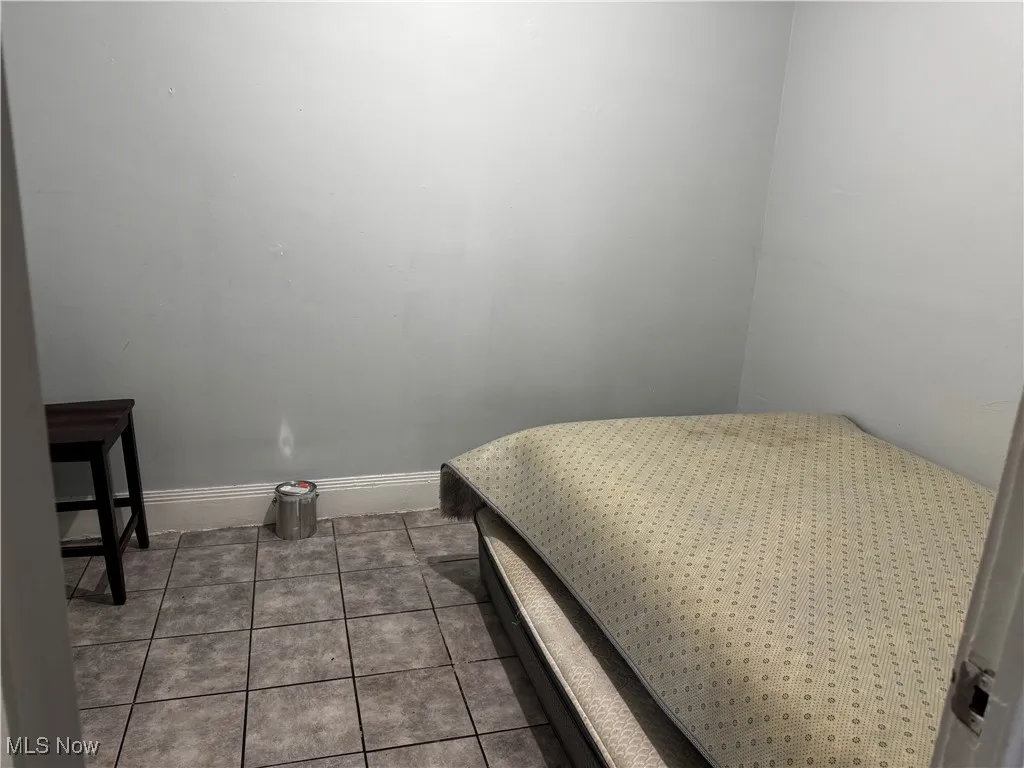 Tiled bedroom featuring baseboards