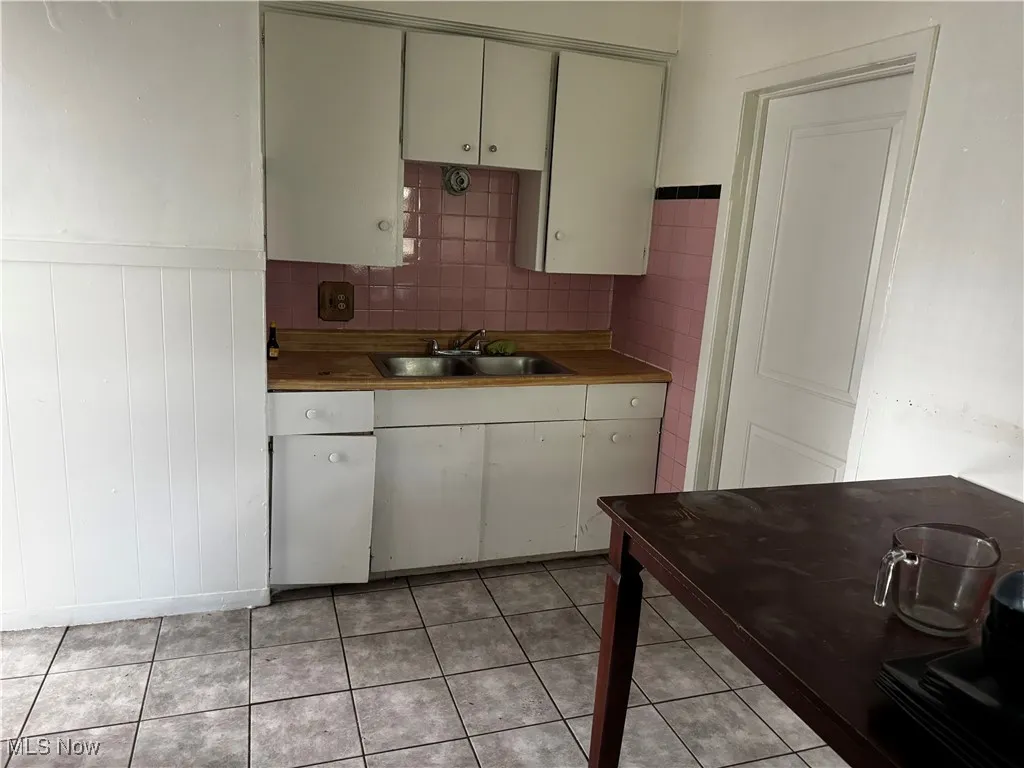 Kitchen featuring wainscoting and light tile patterned floors