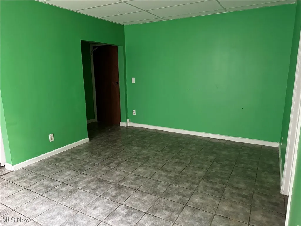 Spare room featuring a drop ceiling and baseboards