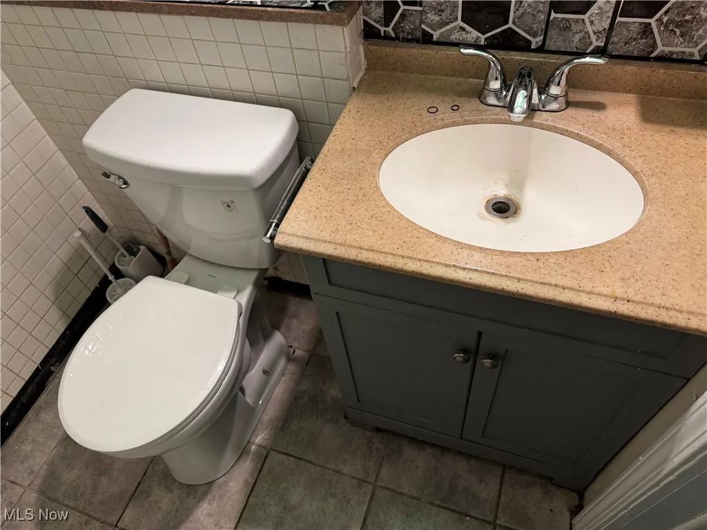 Bathroom featuring vanity, tile walls, and tile patterned floors