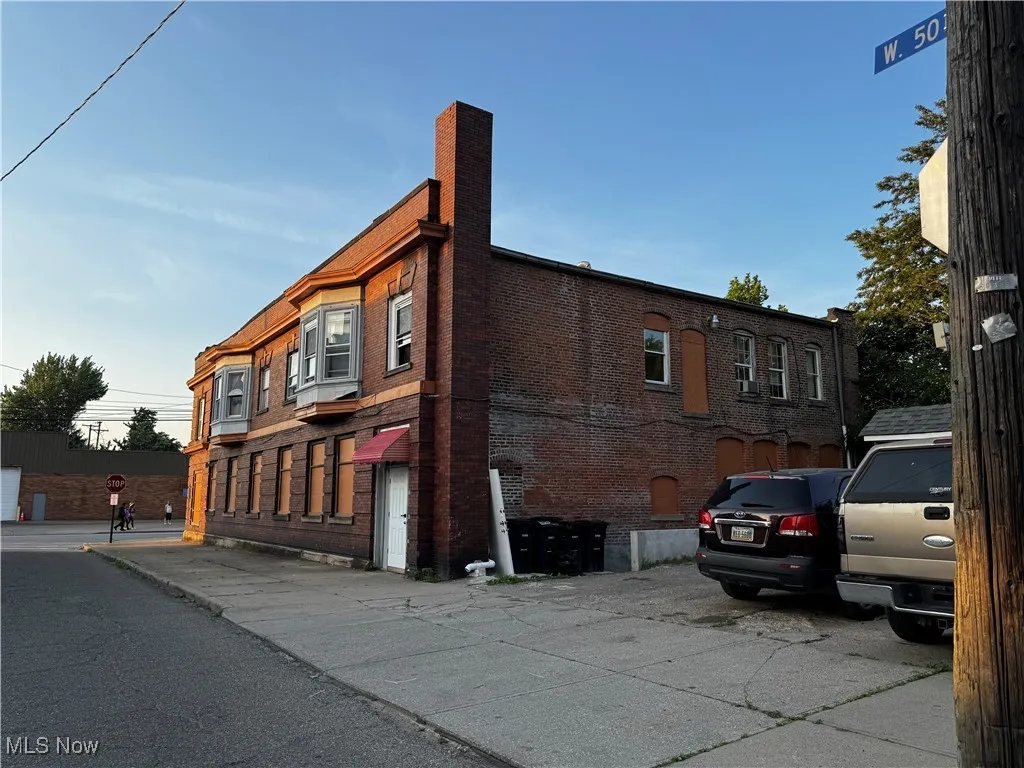 View of side of home featuring brick siding and a chimney