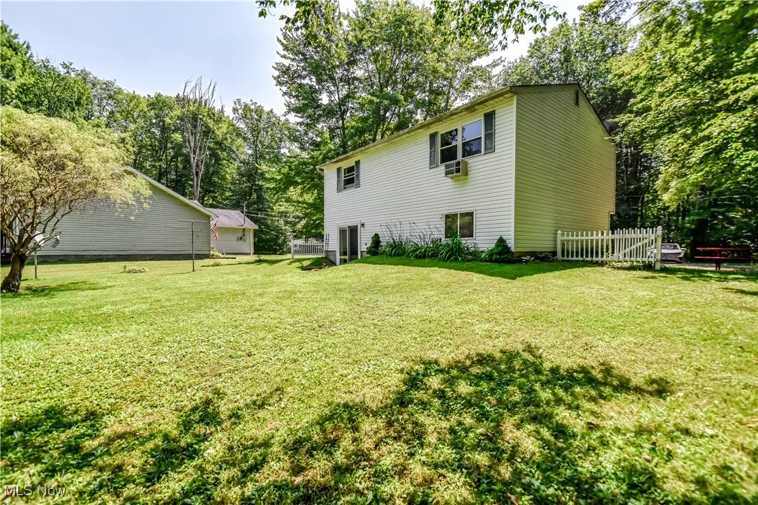 Rear view of property featuring view of scattered trees