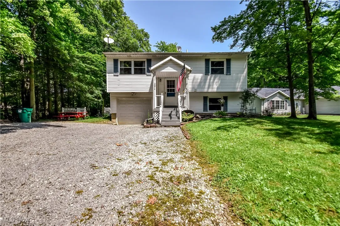 Split foyer home featuring an attached garage, driveway, and a front yard