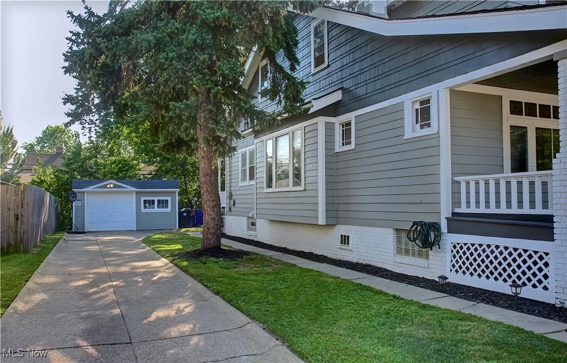 View of home's exterior featuring driveway, an outbuilding, and a garage