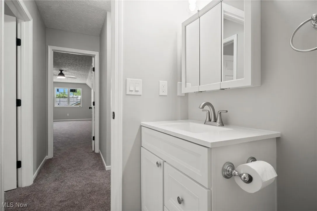 Bathroom with a textured ceiling and vanity