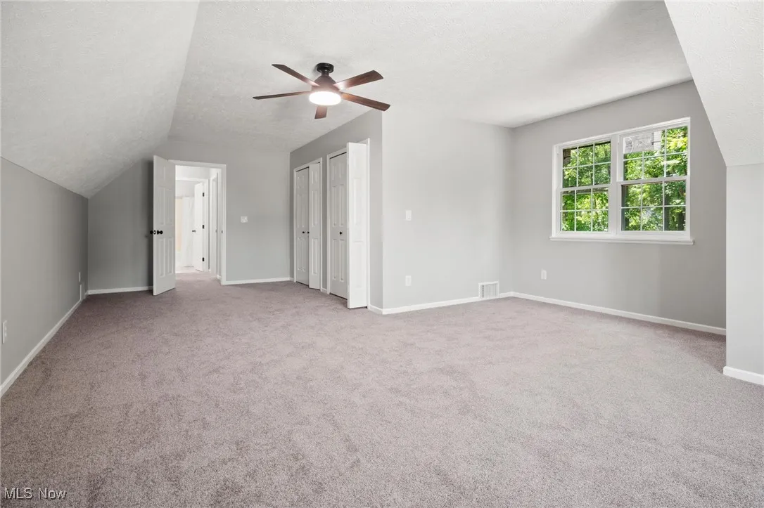Bonus room featuring ceiling fan, carpet floors, a textured ceiling, and vaulted ceiling