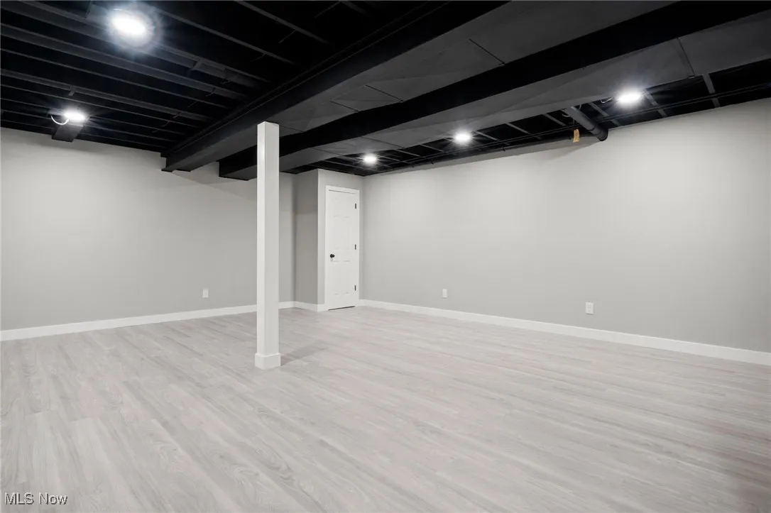 Finished basement featuring wood finished floors and baseboards