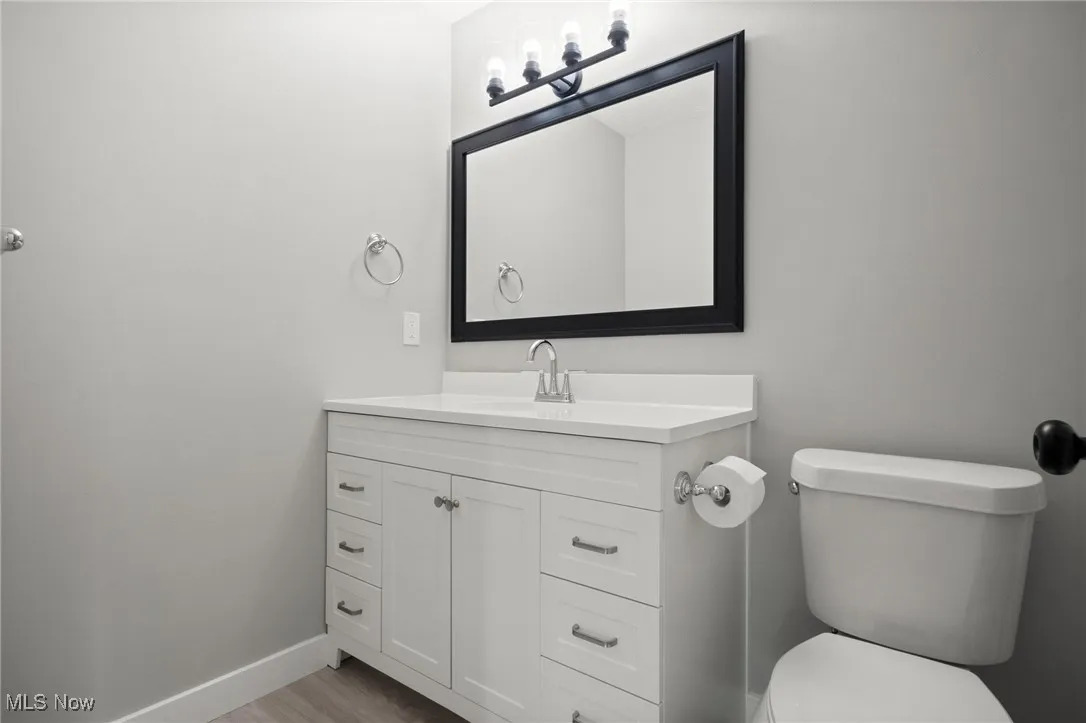 Half bath featuring vanity and wood finished floors