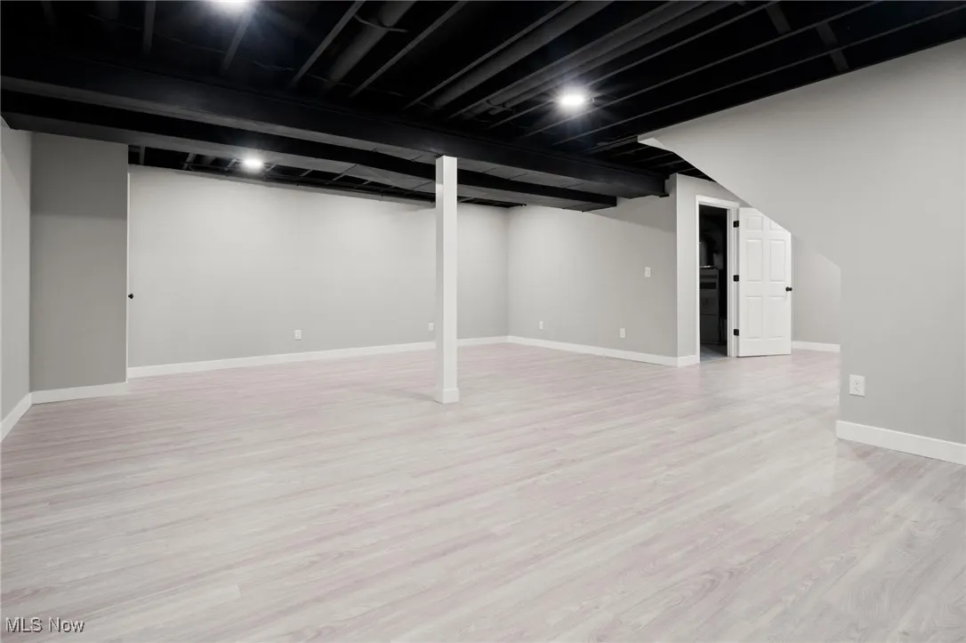 Finished basement with wood finished floors and baseboards