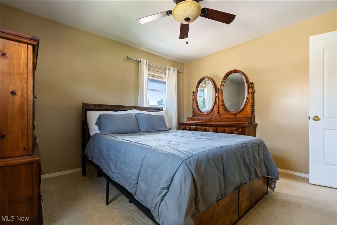 Bedroom featuring light colored carpet and a ceiling fan