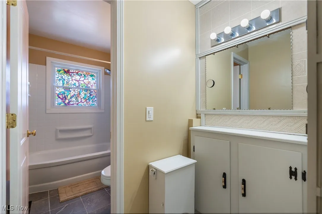 Bathroom with vanity and shower / washtub combination