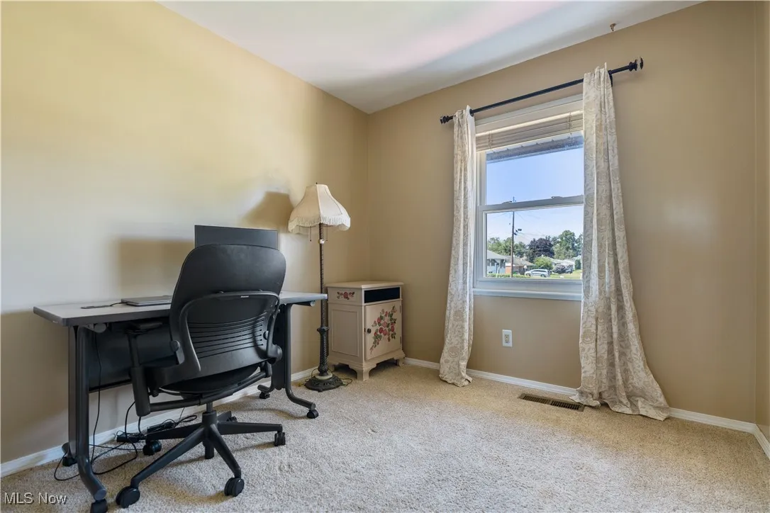 Home office with light carpet and baseboards