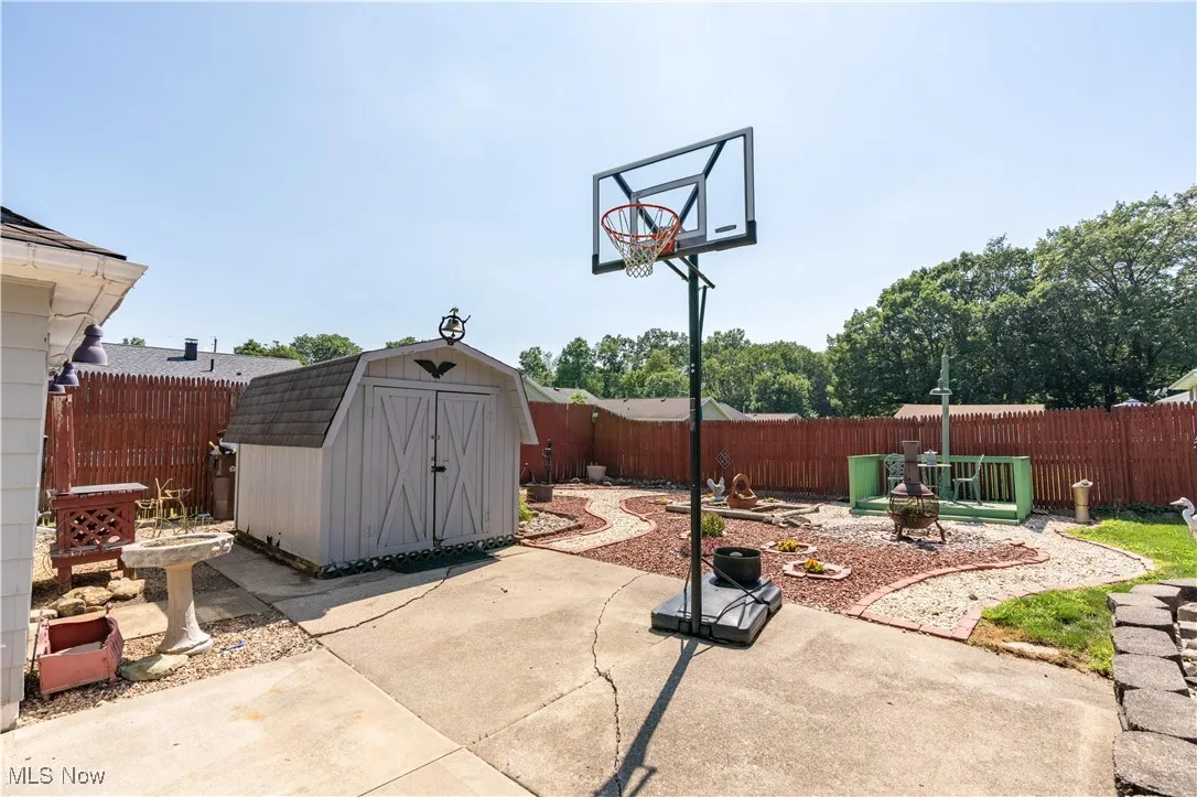Fenced backyard with a patio area and a storage unit