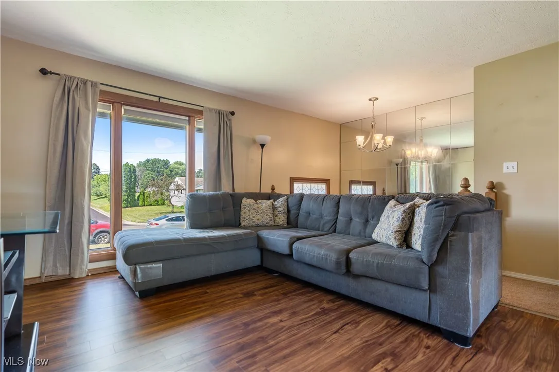 Living area featuring a chandelier and dark wood-style floors
