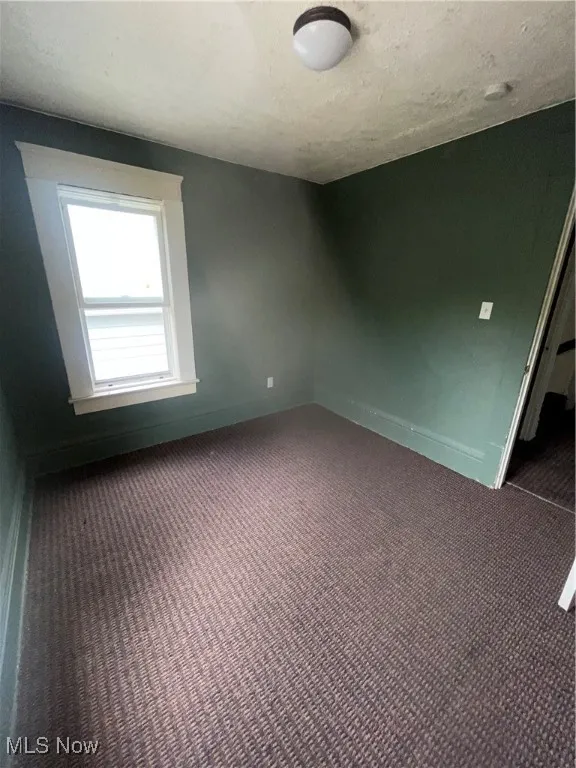 Unfurnished bedroom featuring a textured ceiling and carpet flooring