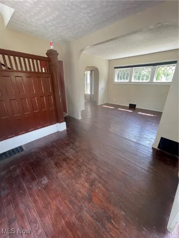 Unfurnished foyer with a textured ceiling, dark wood-style flooring