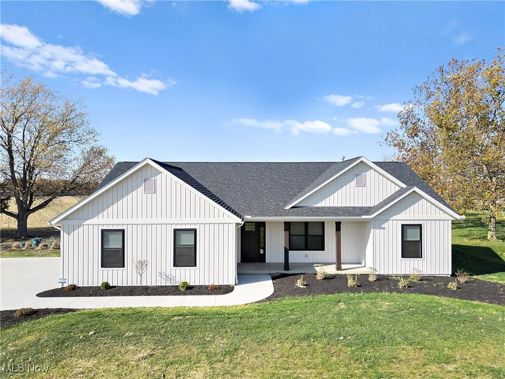 Modern inspired farmhouse featuring a front lawn