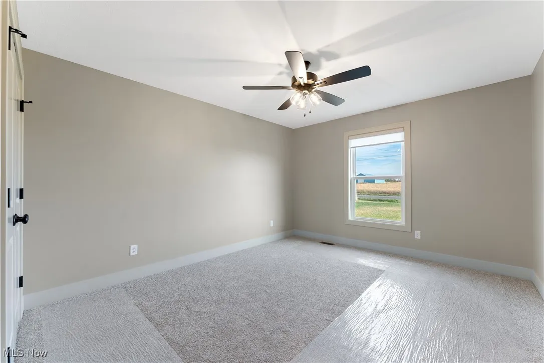 Unfurnished room with light carpet and ceiling fan