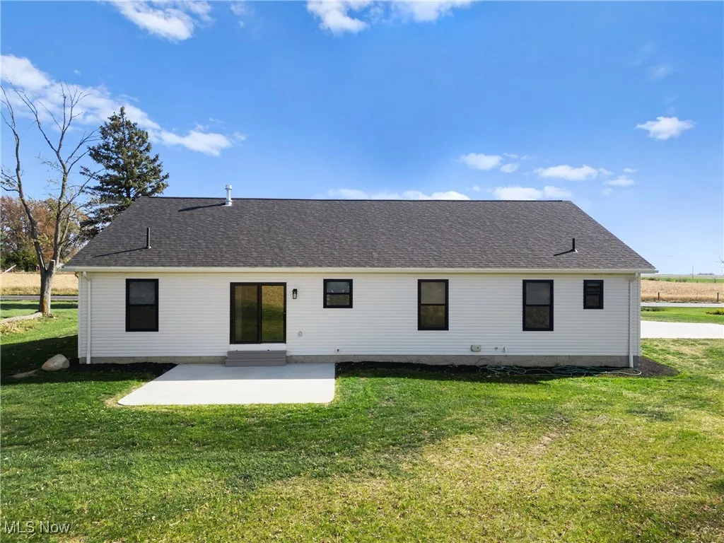 Rear view of property with a yard and a patio area