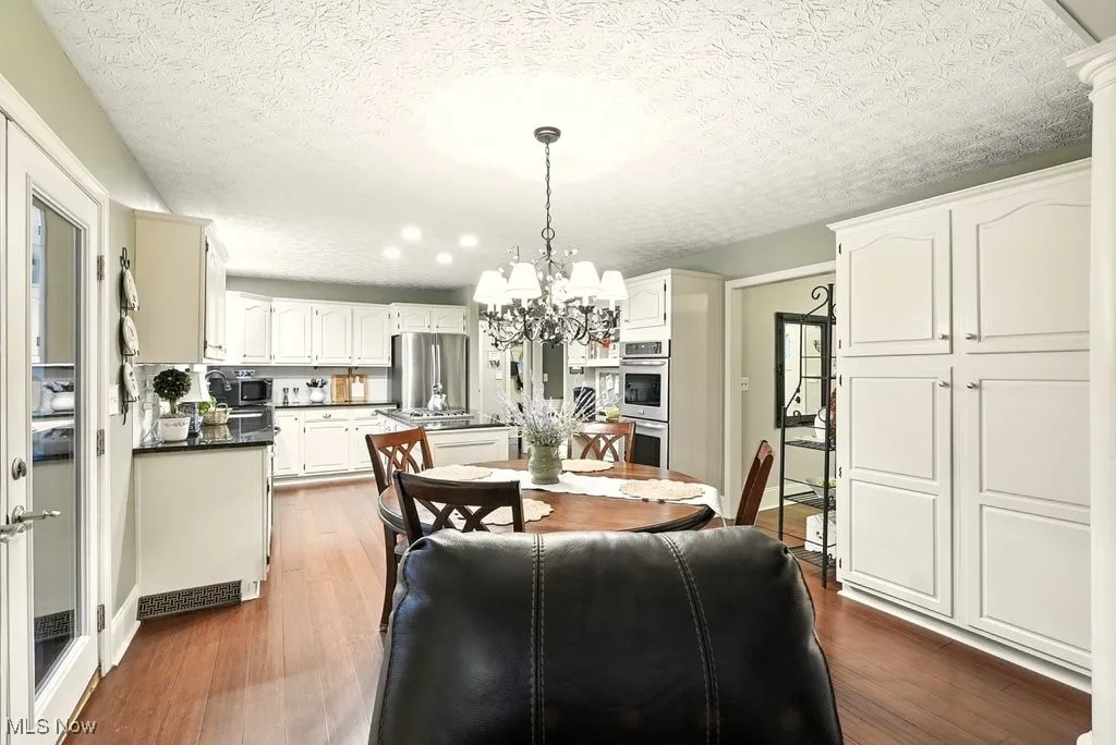 Eat-in Kitchen with Granite Counters, Subway Backsplash, Gas Cooktop, Double Oven, Updated Kitchen Cabinets, Island with a Stove Top, and Extra Wide Baseboards