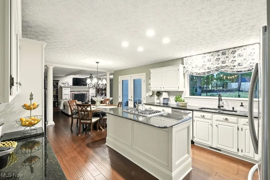 Eat-in Kitchen with Granite Counters, Subway Backsplash, Gas Cooktop, Double Oven, Updated Kitchen Cabinets, Island with a Stove Top, and Extra Wide Baseboards