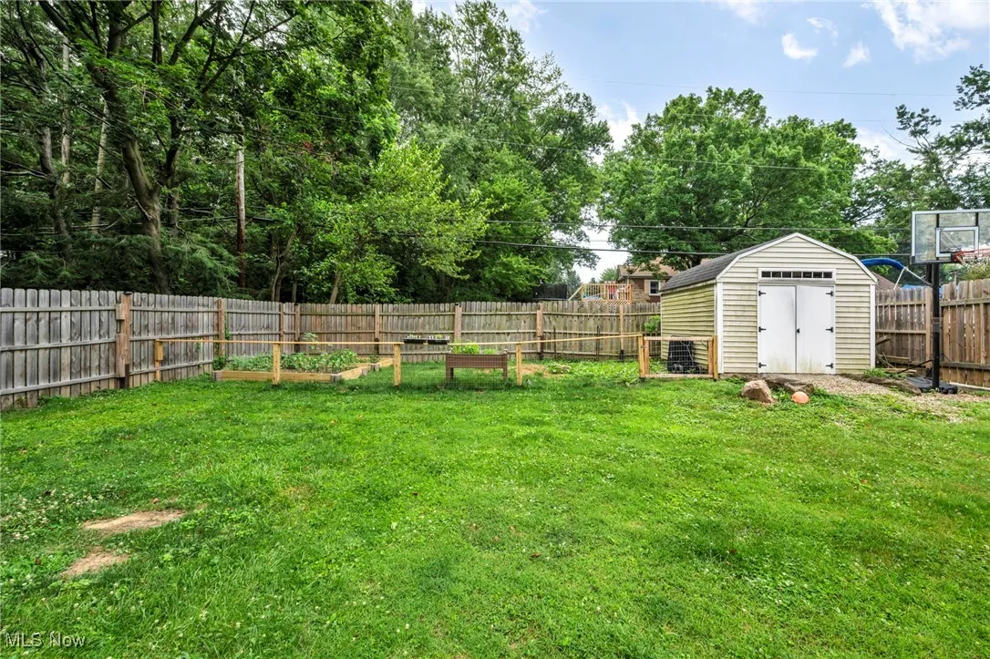 Fenced backyard featuring a garden and a shed
