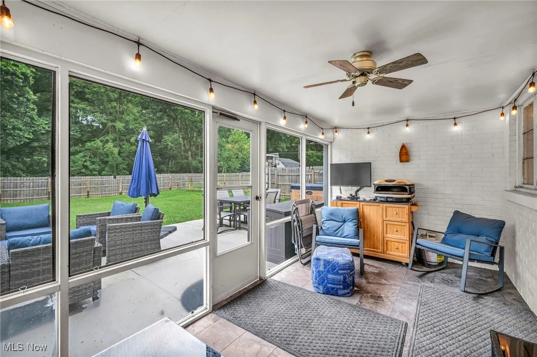 Sunroom / solarium with rail lighting, a ceiling fan, outdoor dining area, and outdoor lounge area