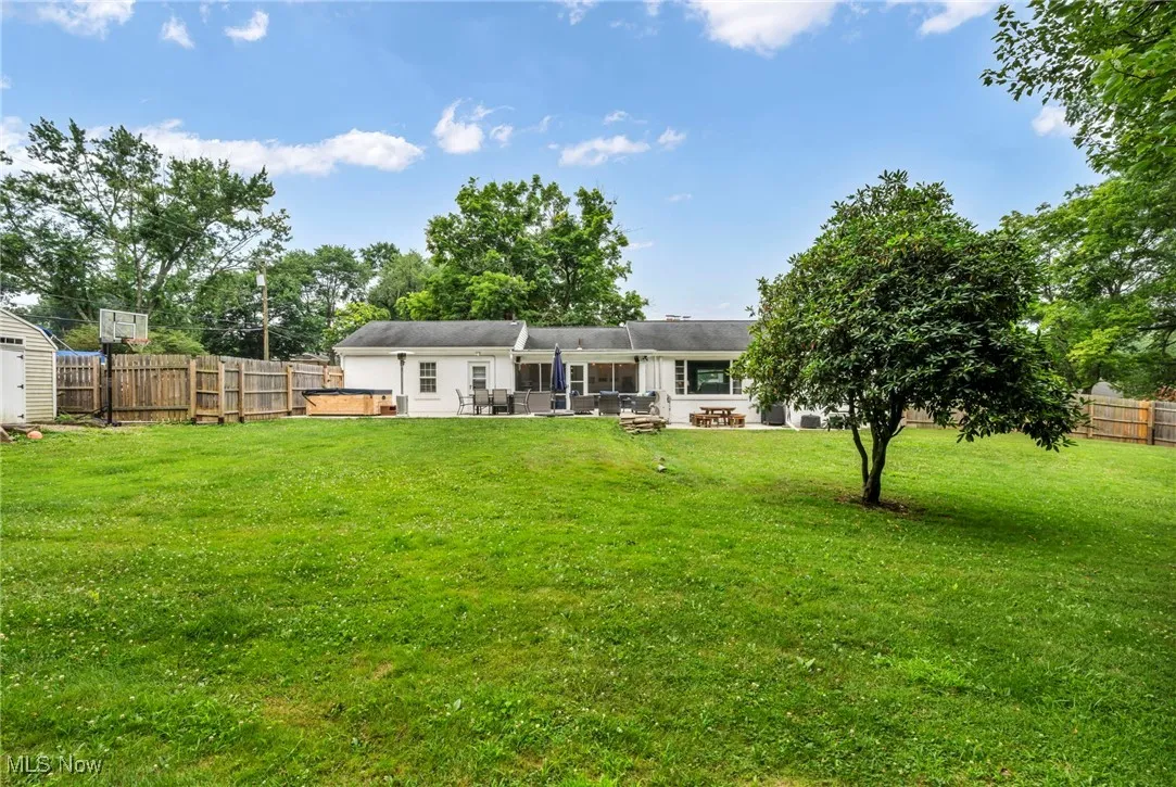 Rear view of property featuring a fenced backyard, a patio, and a storage unit