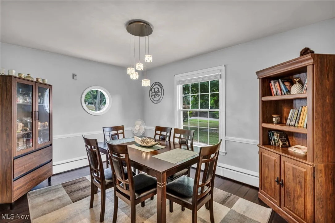 Dining space with dark wood-type flooring, a baseboard radiator, and a baseboard heating unit