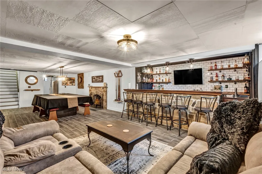 Living room with bar with sink and wood tiled floors