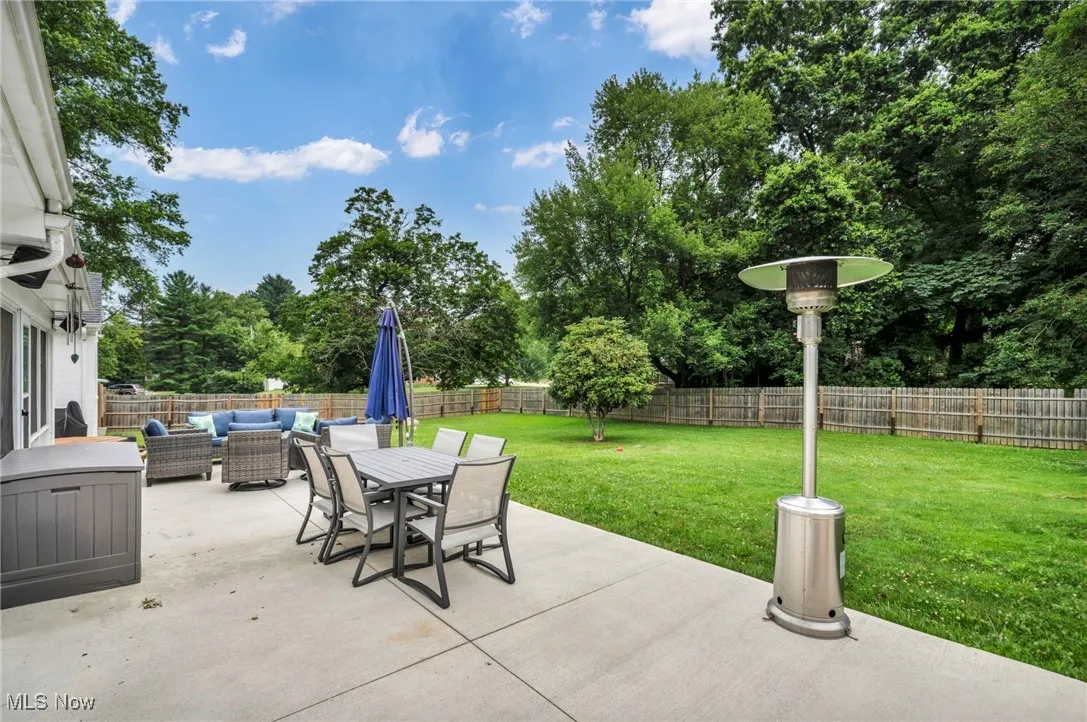 Fenced backyard with outdoor lounge area, a patio area, outdoor dining space, and view of scattered trees