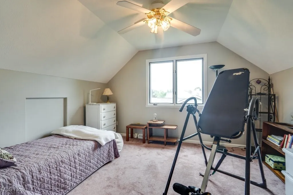 Bedroom featuring lofted ceiling, light carpet, and a ceiling fan