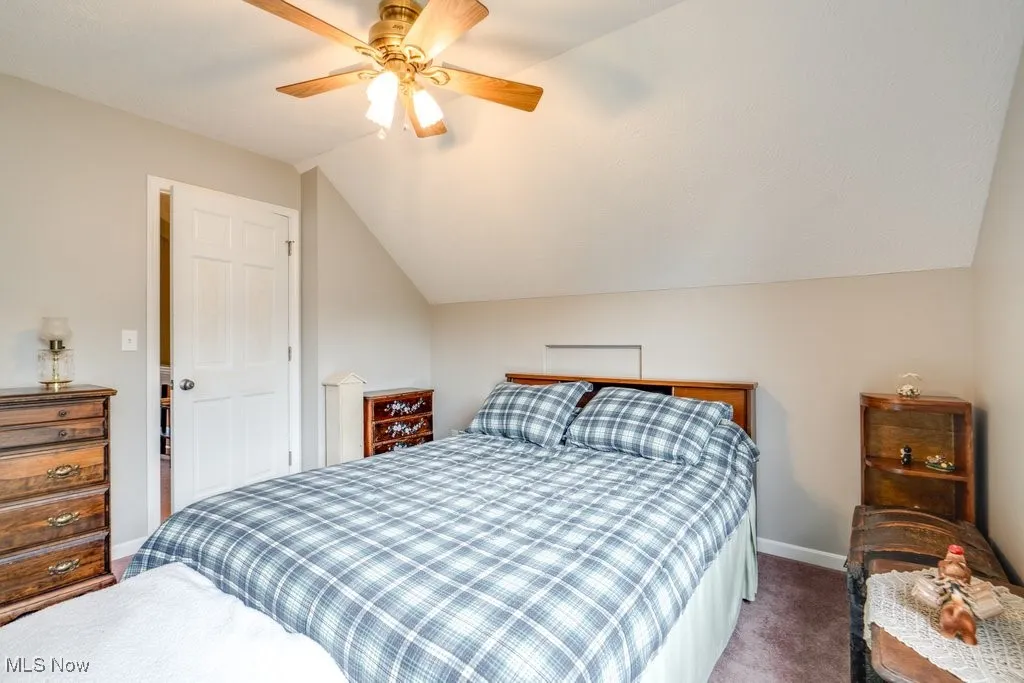 Bedroom with carpet, vaulted ceiling, and a ceiling fan