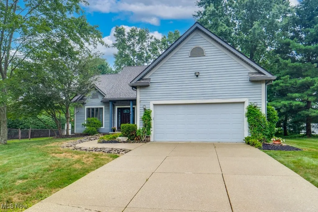 View of front facade featuring concrete driveway and an attached garage