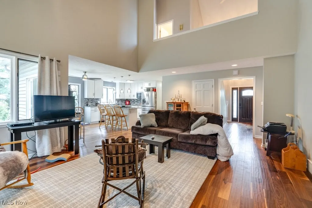 Living room featuring light wood finished floors and a towering ceiling