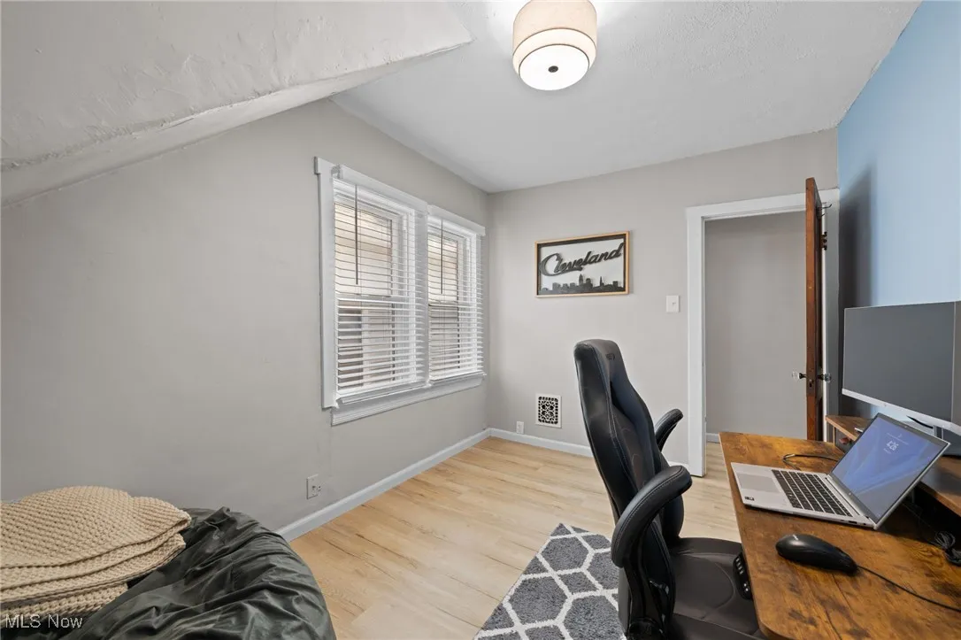 Bedroom with wood style floors and baseboards