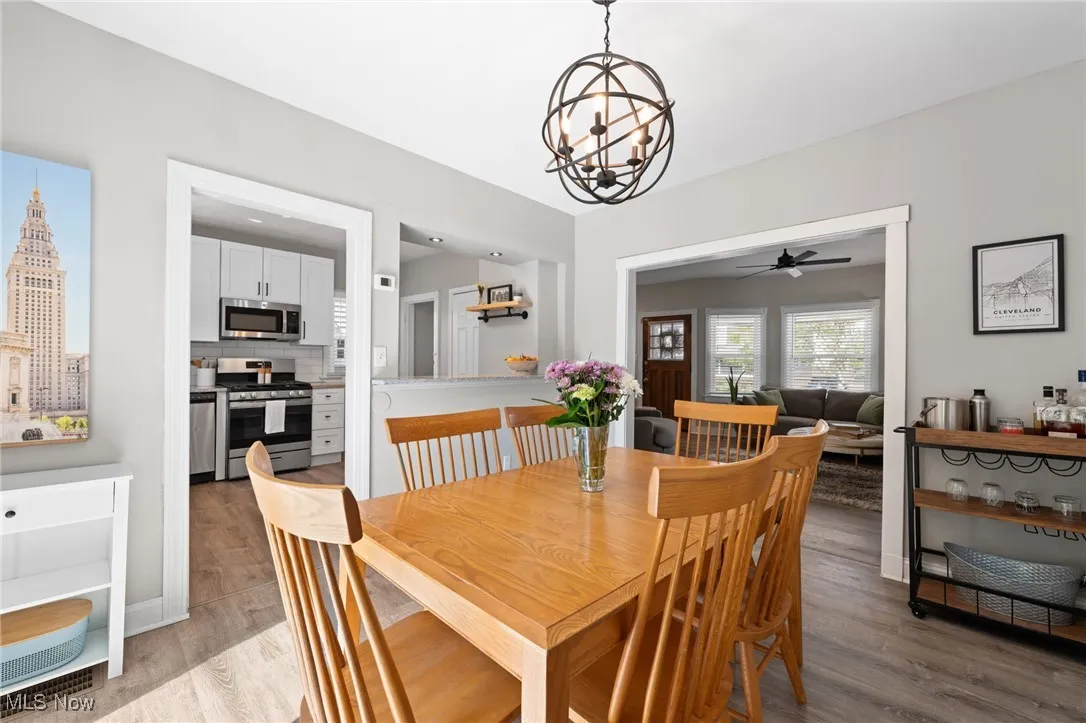 Dining room with light wood-type flooring, and a chandelier