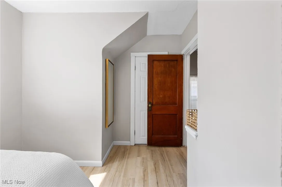 Owner's bedroom with light wood-style floors and baseboards