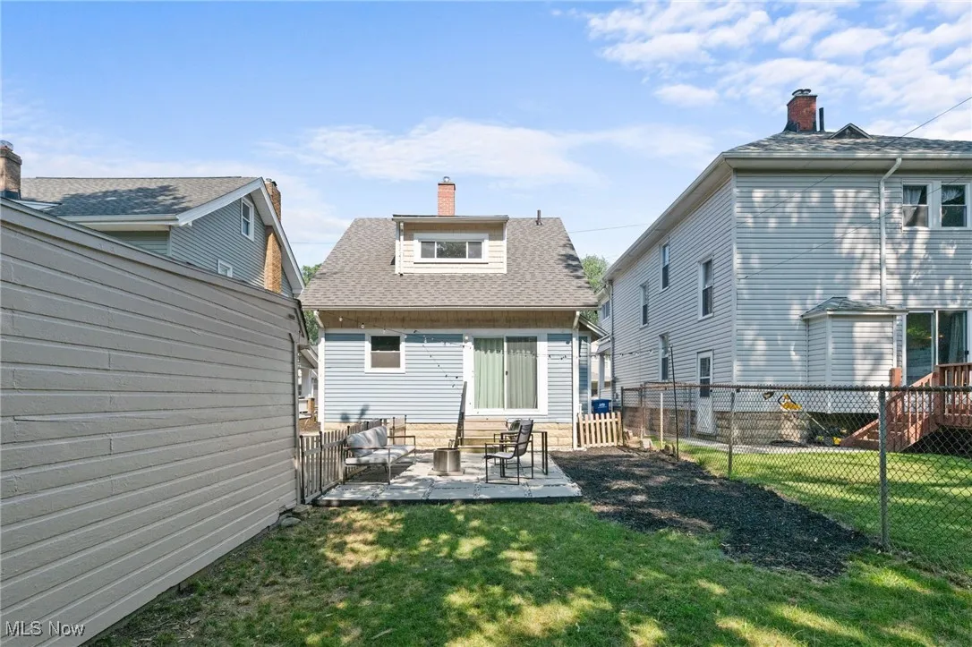 Back of property with  a fenced backyard, and a patio