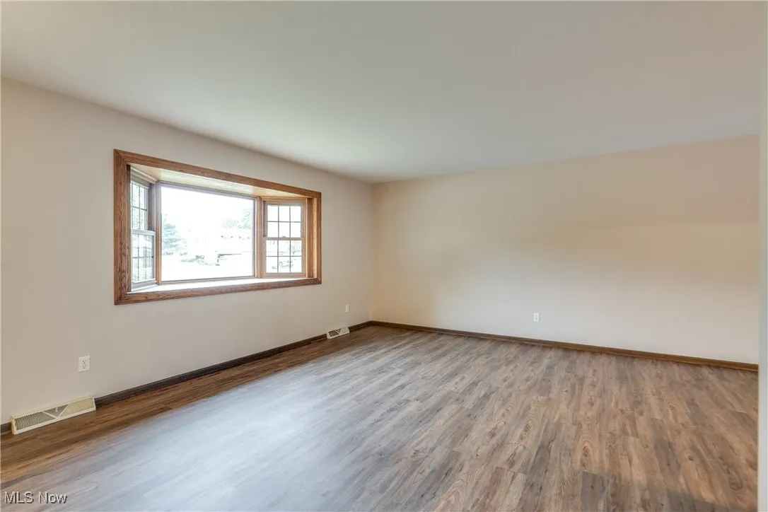 Spare room with wood finished floors and baseboards