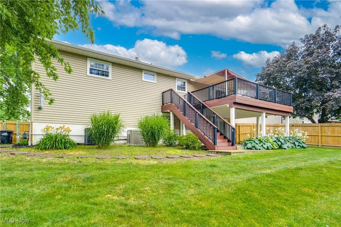 Back of property featuring a deck and stairs