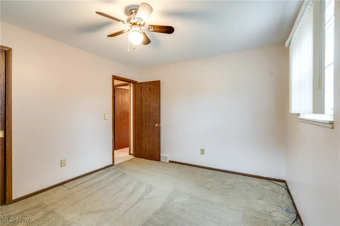 Unfurnished room featuring a ceiling fan and carpet flooring