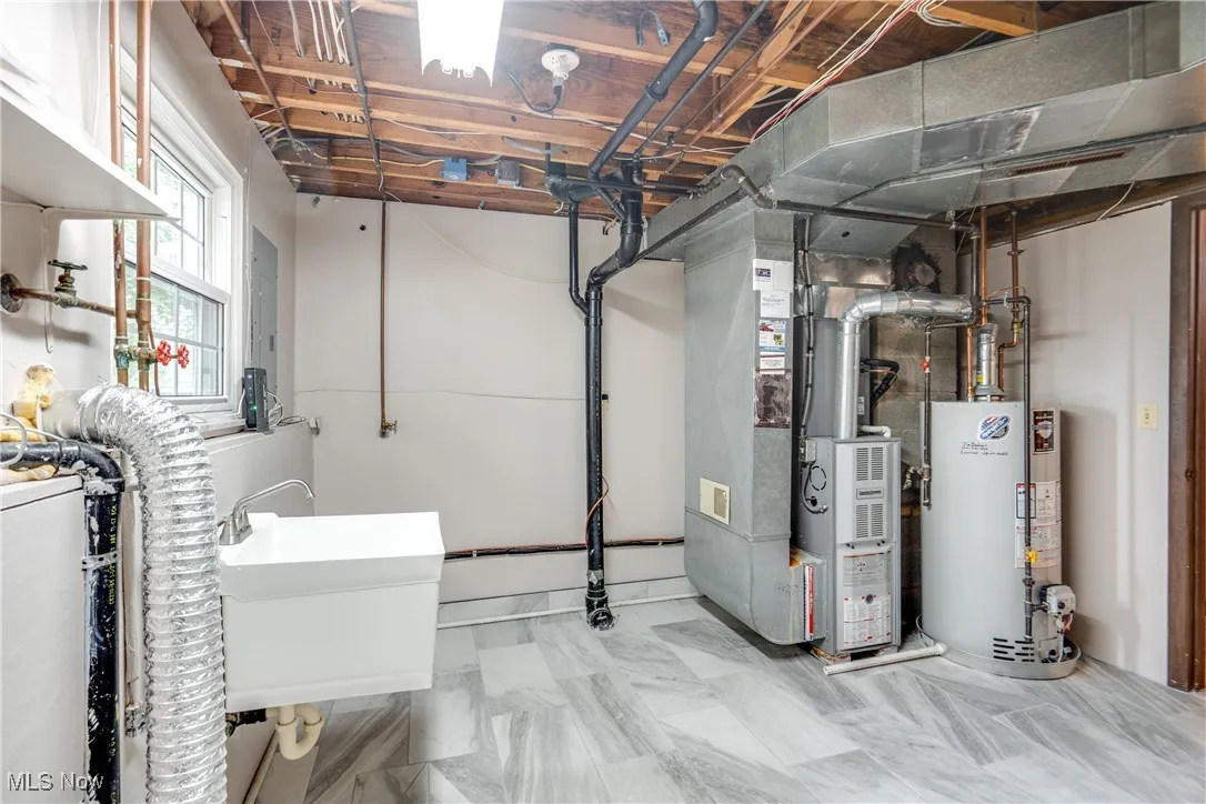 Basement featuring gas water heater and heating unit