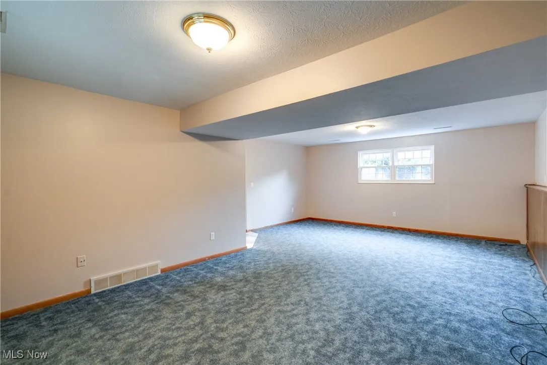 Basement featuring carpet flooring and baseboards