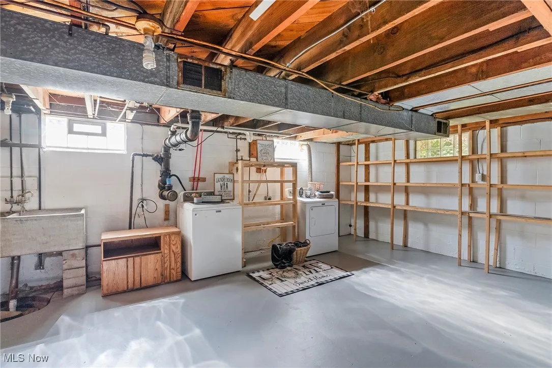 Basement with washer and dryer and concrete block wall
