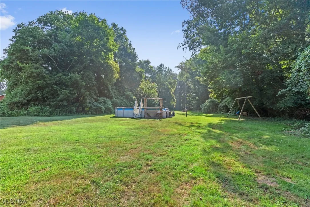 View of green lawn featuring an outdoor pool